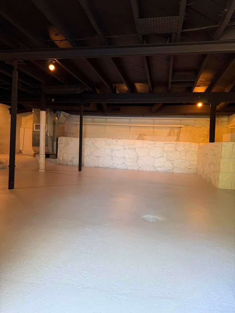 Empty warehouse or industrial space with polished concrete floor, exposed beams, metal support columns, and warm lighting.