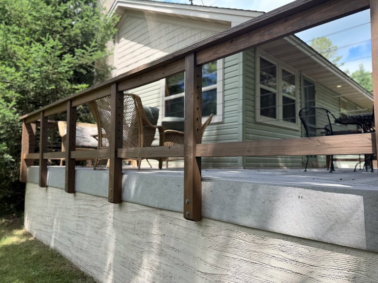 Outdoor covered patio with wooden frame and screen panels attached to a residential house with green siding